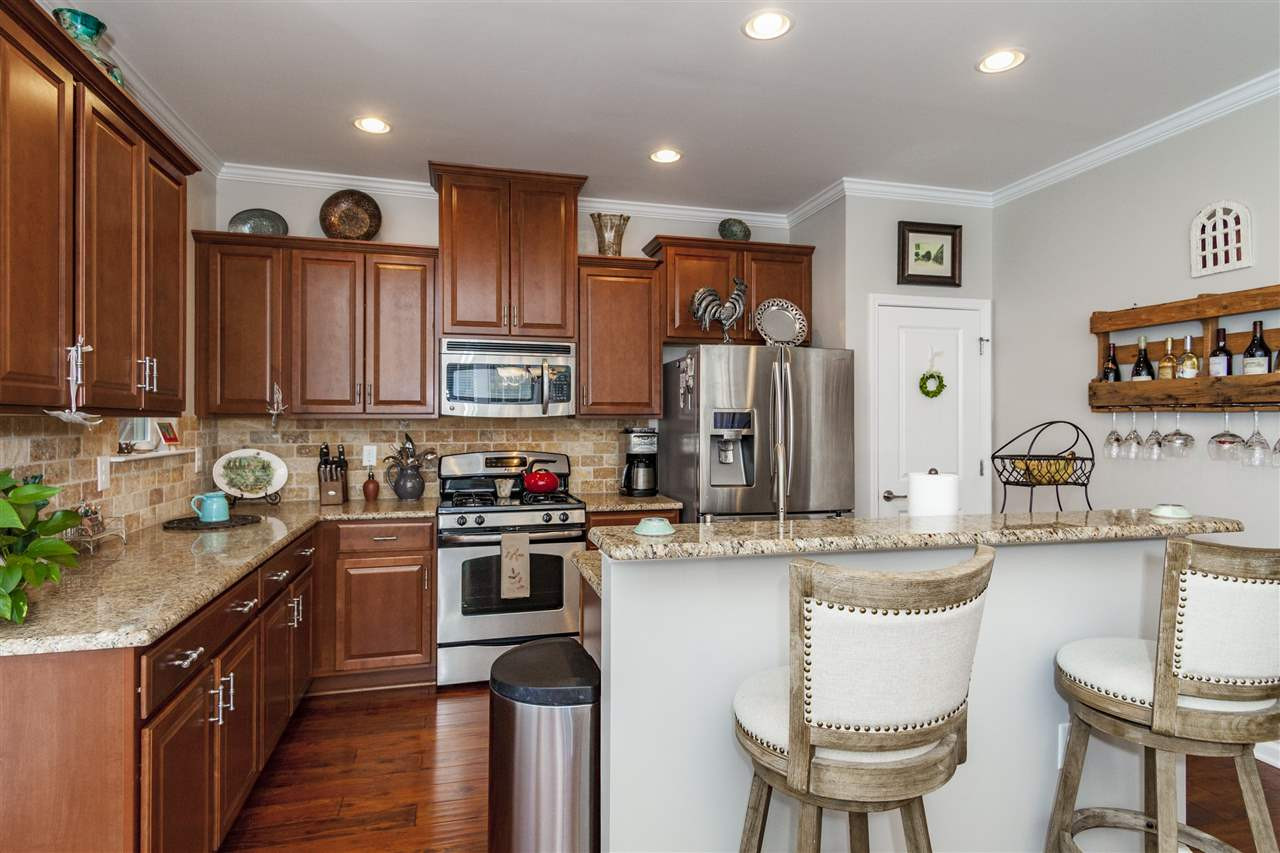 1434 Van Page Boulevard Raleigh, NC 27607 - Photo 11 of 25 Enjoy this incredible kitchen with the unique stone backsplash. Ample storage space in cabinets and pantry with wooden shelving! Kitchen