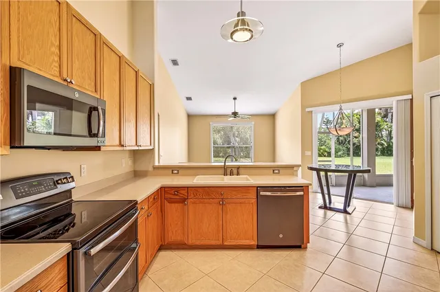 a kitchen that has a sink a stove and chairs