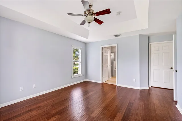 a view of an empty room with window and wooden floor