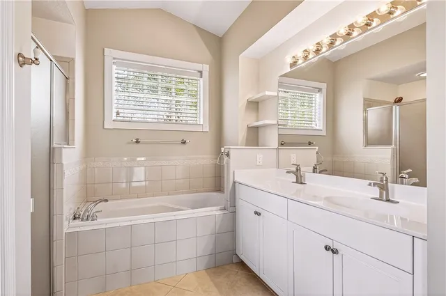 a bathroom with a tub sink and mirror