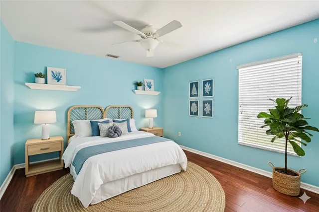 a bedroom with a large bed and a potted plant
