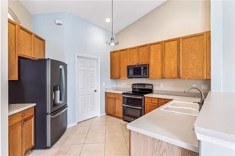 a kitchen with stainless steel appliances granite countertop a refrigerator stove and sink