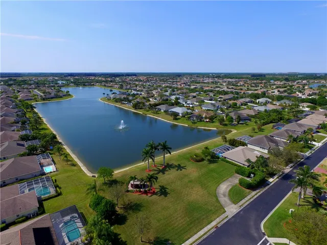 an aerial view of a city with lots of residential buildings ocean and mountain view in back