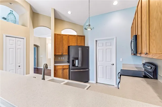 a kitchen with stainless steel appliances granite countertop a refrigerator and a stove top oven