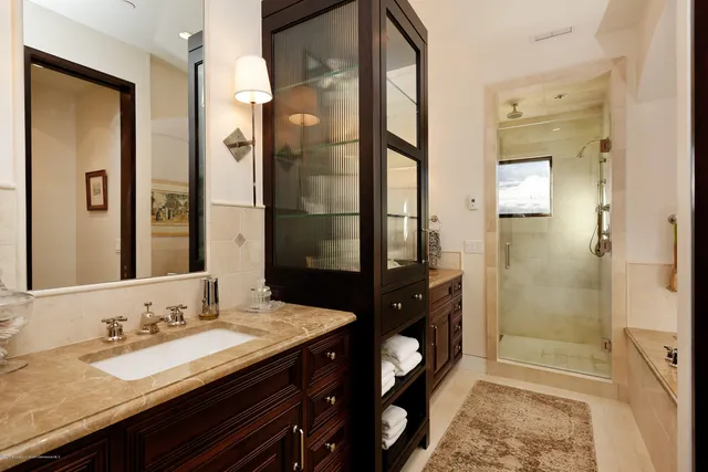 a bathroom with a granite countertop sink a mirror and a shower