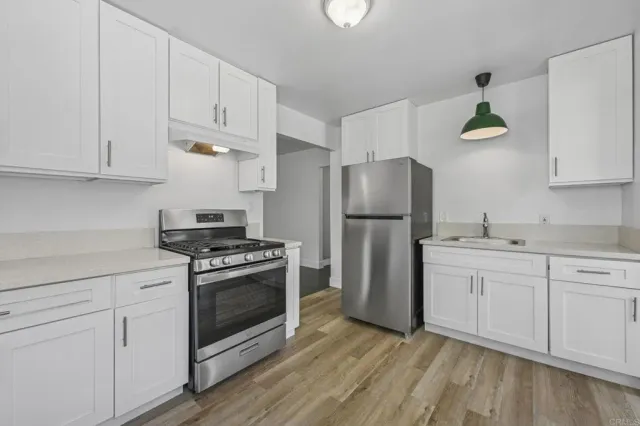 a kitchen with white cabinets and stainless steel appliances