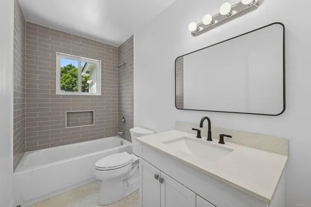 a bathroom with a toilet a sink a mirror and bathtub