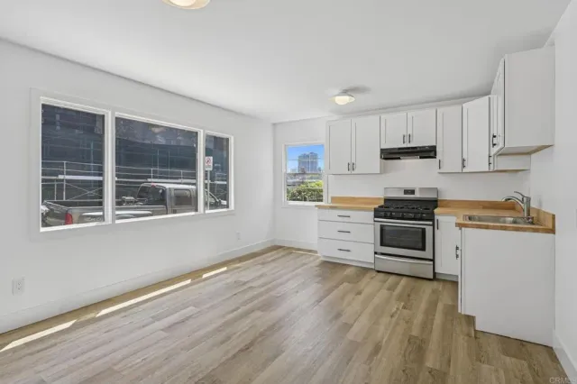 a kitchen with granite countertop a refrigerator and wooden cabinets