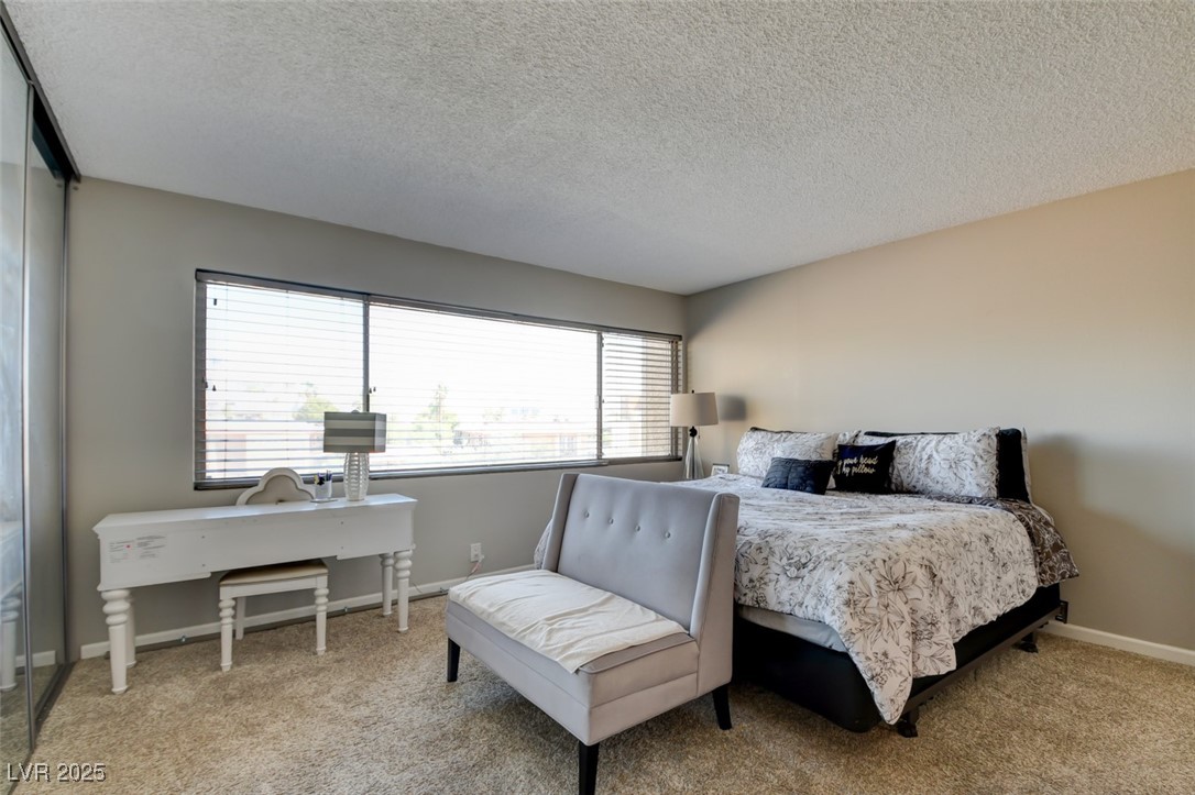 745 North Royal Crest Circle, Unit 127 Las Vegas, NV 89169 - Photo 11 of 26 Bedroom with light colored carpet, a textured ceiling, and baseboards