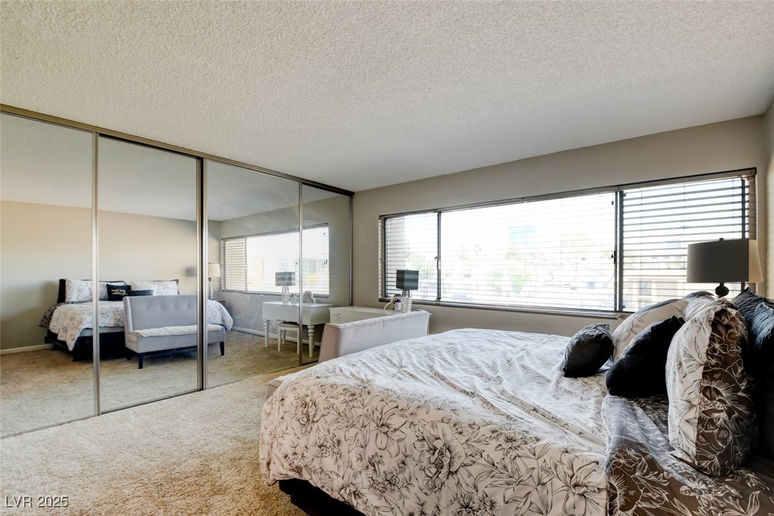745 North Royal Crest Circle, Unit 127 Las Vegas, NV 89169 - Photo 12 of 26 Bedroom with a textured ceiling, carpet, and a closet