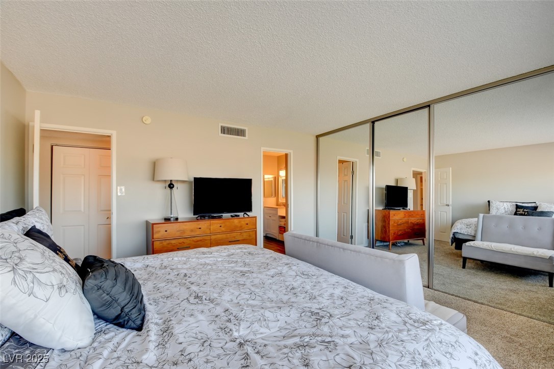 745 North Royal Crest Circle, Unit 127 Las Vegas, NV 89169 - Photo 10 of 26 Bedroom featuring carpet flooring, a closet, and a textured ceiling