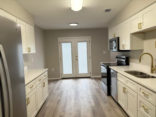 a kitchen with a sink a stove a refrigerator and cabinets