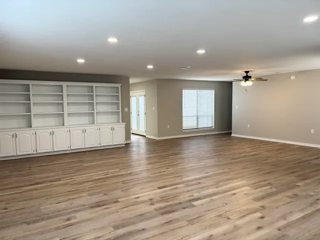 a view of a room with wooden floor and window