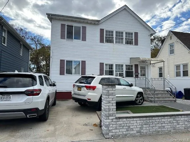 a view of a white car parked in front of a house