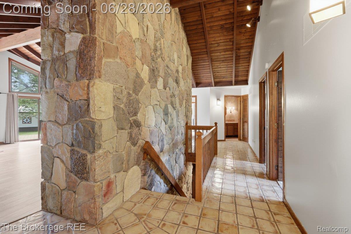 8475 Knox Road Clarkston, MI 48348 - Photo 11 of 71 Stone accent wall with wood railing and patterned tile flooring