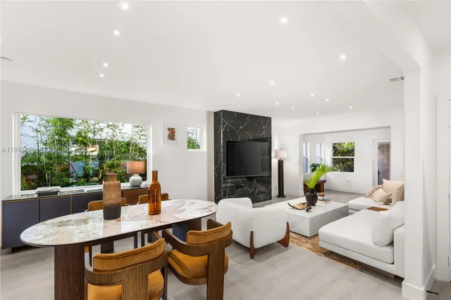 a kitchen with stainless steel appliances a table chairs and a refrigerator