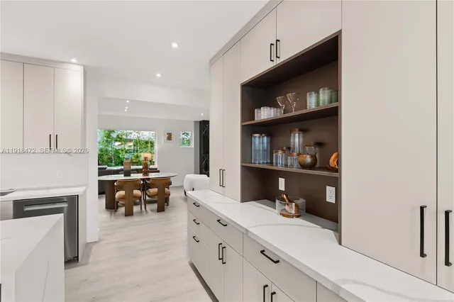 a kitchen with a dining table chairs and white appliances