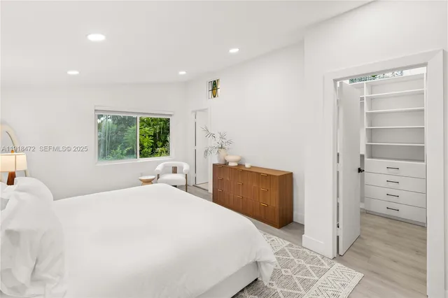 a bedroom with a bed and a refrigerator