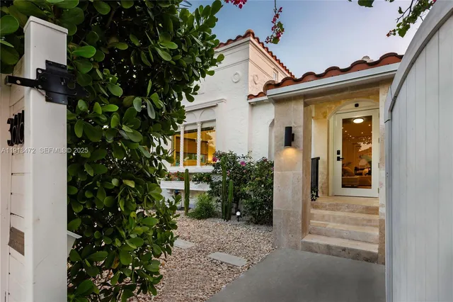 a view of a house with a potted plant and floor to ceiling window