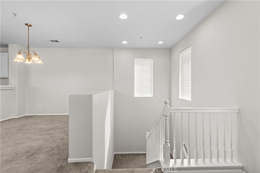 33657 Emerson Way, Unit C Temecula, CA 92592 - Photo 19 of 32 a view of a hallway with windows and chandelier