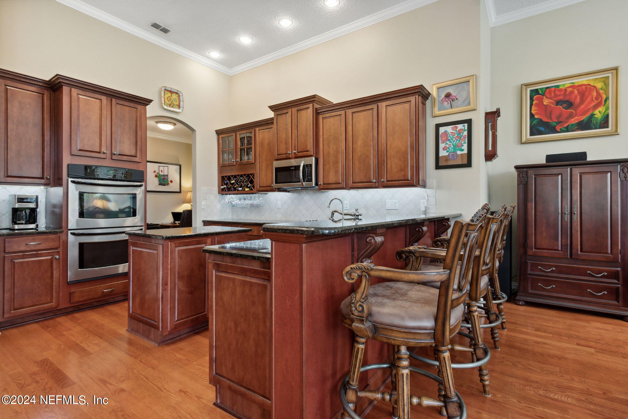 270 Holland Drive St. Augustine, FL 32095 - Photo 11 of 60 a kitchen with stainless steel appliances kitchen island granite countertop a table chairs in it and a wooden floors
