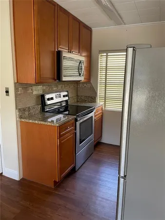 a kitchen with stainless steel appliances granite countertop a stove a microwave and a refrigerator