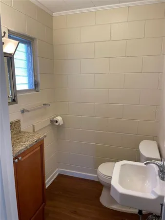 a bathroom with a granite countertop toilet a sink and mirror