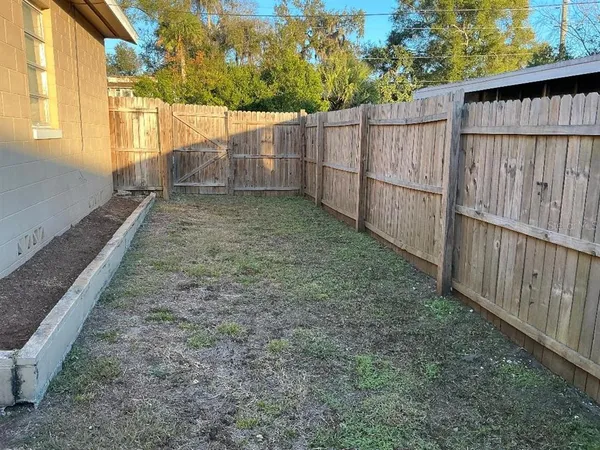 a view of a backyard with wooden fence