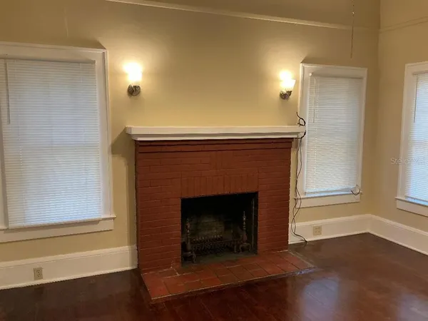 a living room with a fireplace and wooden floor