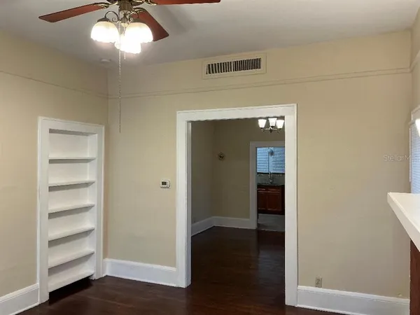 a view of a hallway with wooden floor and closet