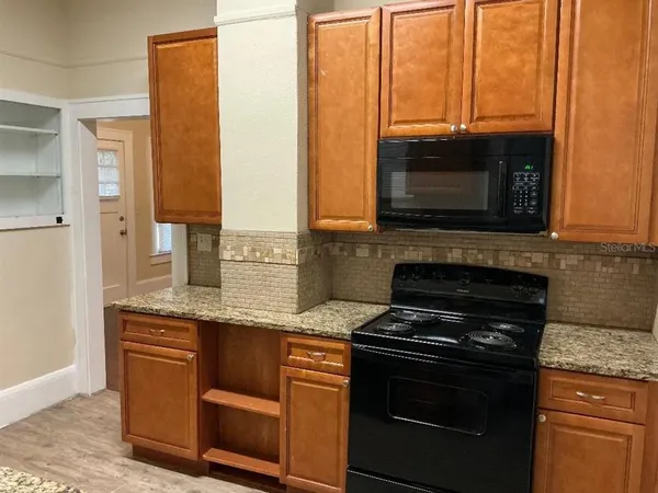 a kitchen with stainless steel appliances granite countertop a stove a microwave and a sink
