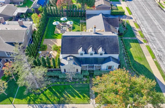 an aerial view of a house with a yard and a large tree