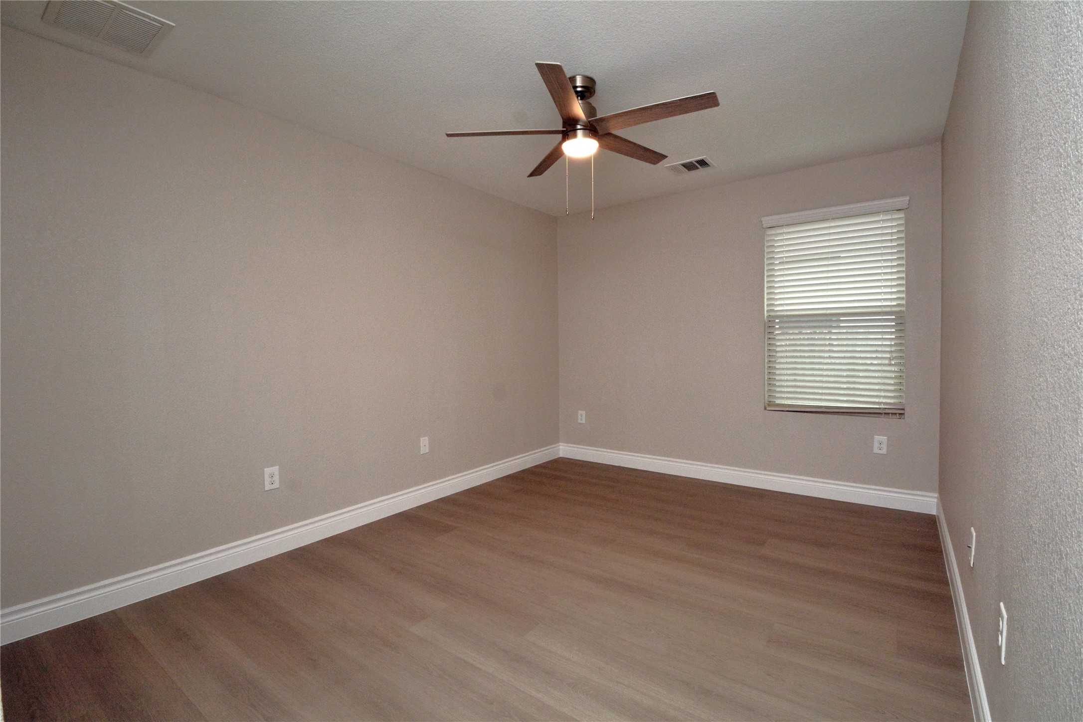 3901 Colorado High Avenue Austin, TX 78744 - Photo 21 of 39 an empty room with wooden floor ceiling fan and windows