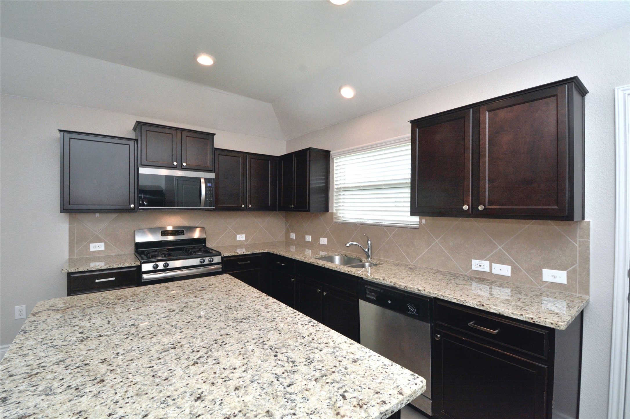 3901 Colorado High Avenue Austin, TX 78744 - Photo 5 of 39 a kitchen with granite countertop stainless steel appliances a sink a stove a microwave a counter top and cabinets
