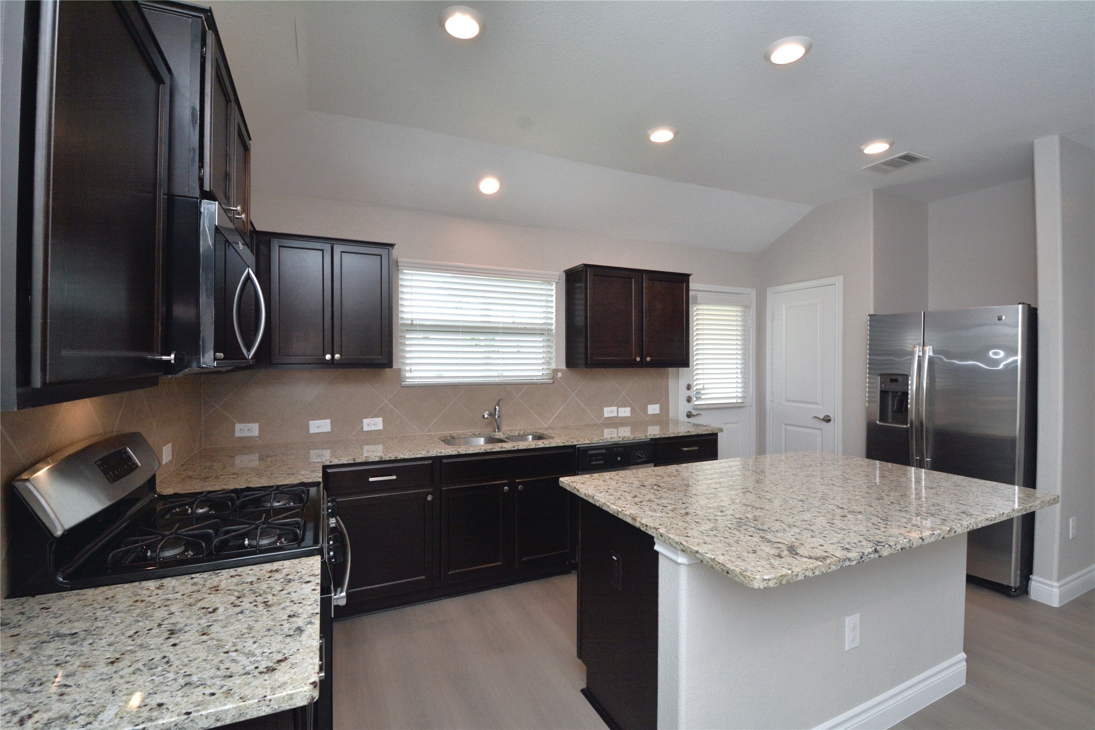 3901 Colorado High Avenue Austin, TX 78744 - Photo 6 of 39 a kitchen with stainless steel appliances granite countertop a sink stove and refrigerator