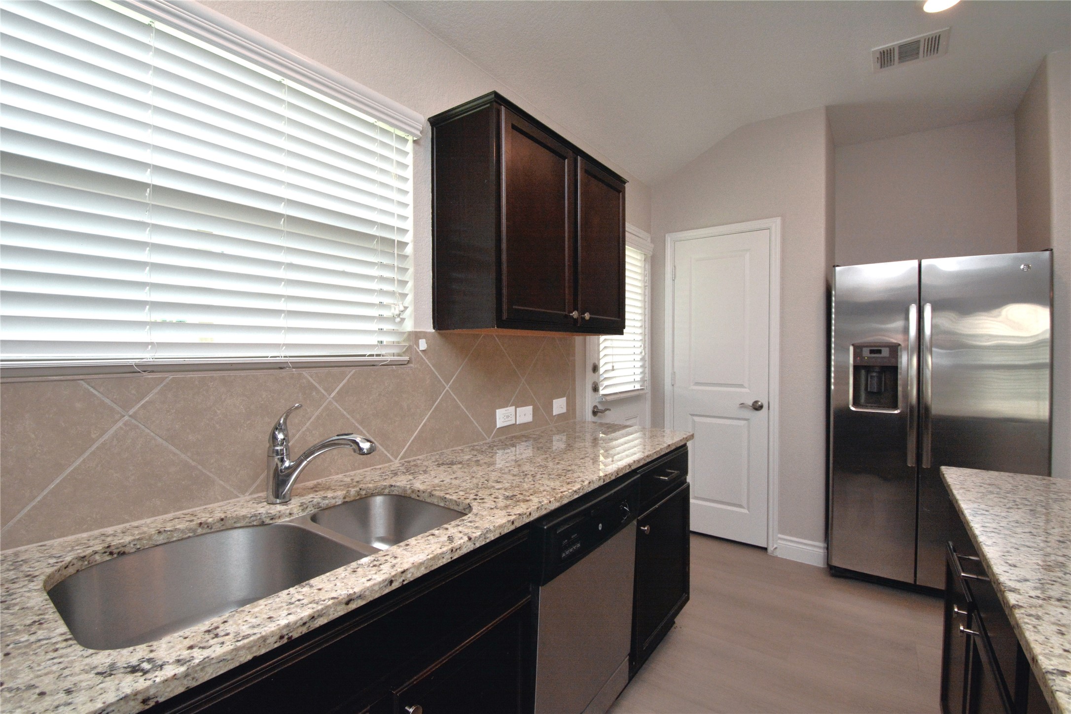 3901 Colorado High Avenue Austin, TX 78744 - Photo 7 of 39 a kitchen with granite countertop a sink and a refrigerator