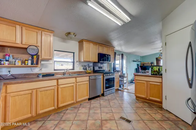 a kitchen with stainless steel appliances granite countertop a sink a stove and a refrigerator