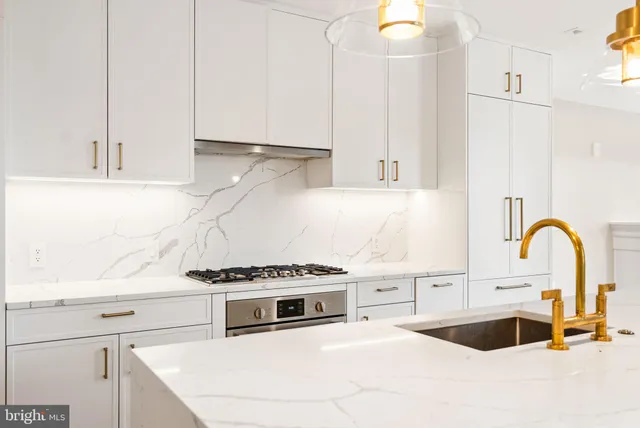 a kitchen with a sink and a stove top oven