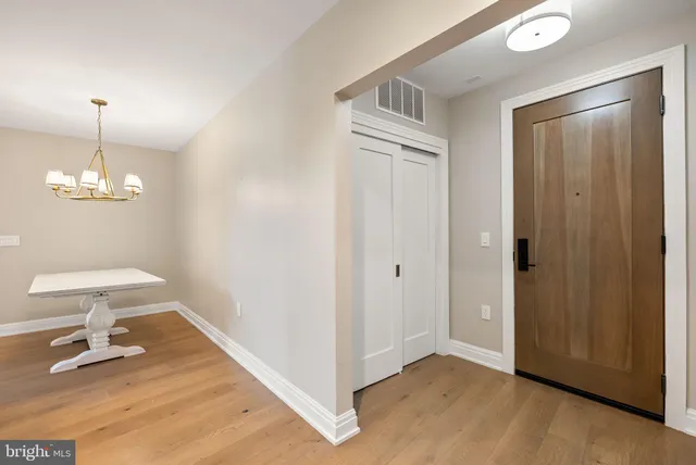 a view of a livingroom with wooden floor and a chandelier