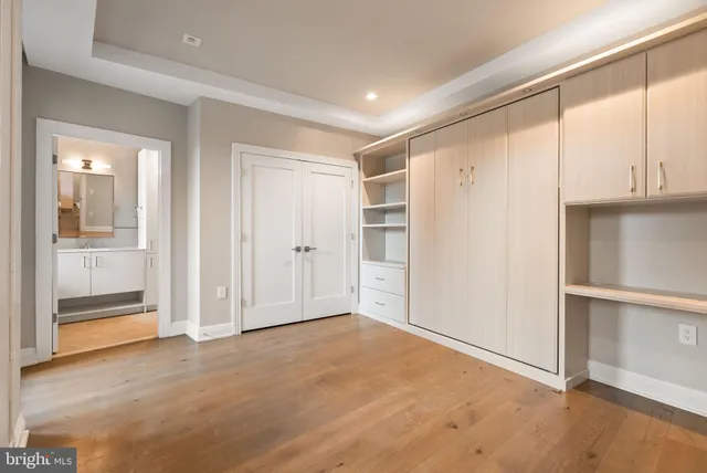 an empty room with cabinet and mirrors