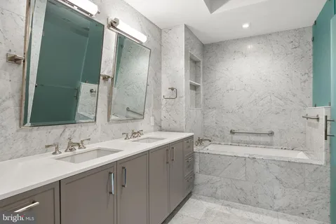 a bathroom with a double vanity sink mirror and shower