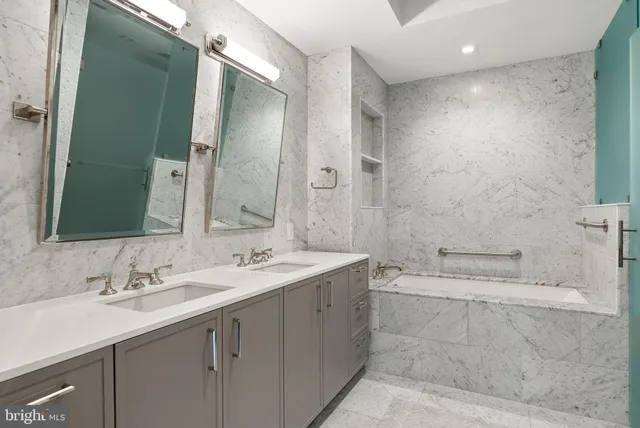 a bathroom with a double vanity sink mirror and shower