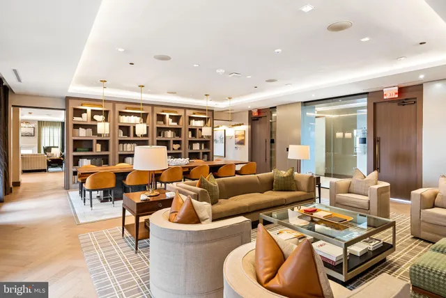 a living room with furniture a flat screen tv and kitchen view