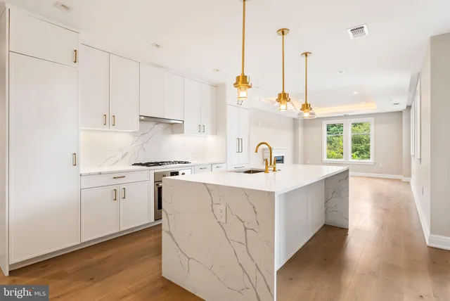 a kitchen with sink stove and cabinets