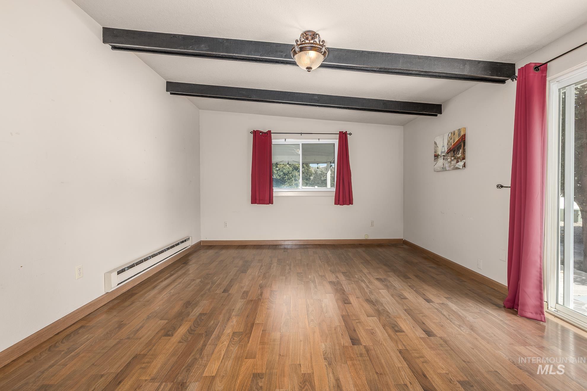 885 Airport Road Vale, OR 97918 - Photo 12 of 36 Unfurnished room featuring beamed ceiling, a baseboard radiator, and light wood finished floors