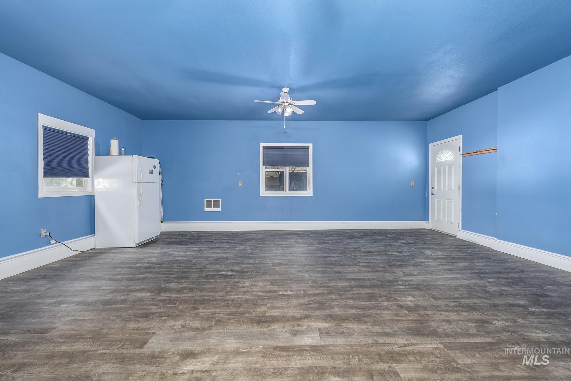 885 Airport Road Vale, OR 97918 - Photo 15 of 36 Empty room with a ceiling fan and dark wood-style floors