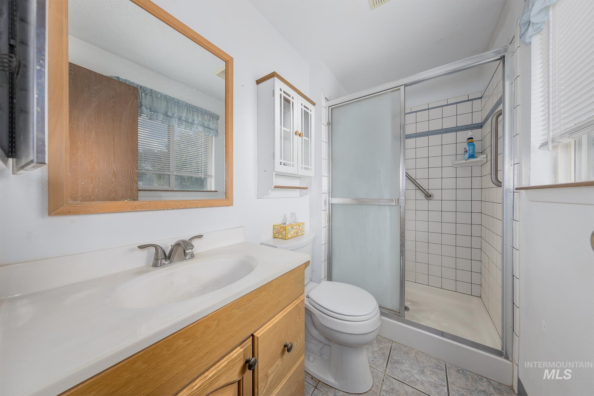 885 Airport Road Vale, OR 97918 - Photo 21 of 36 Bathroom with a stall shower, vanity, and light tile patterned floors