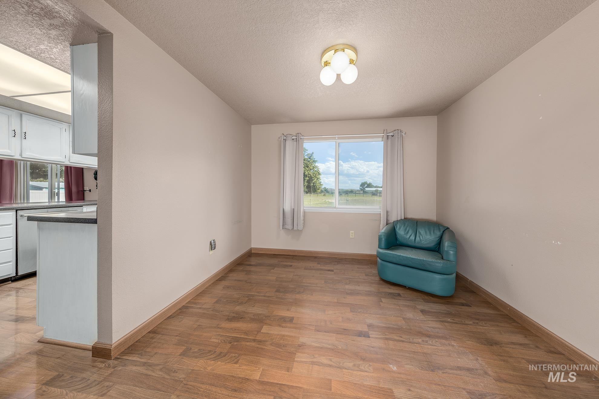 885 Airport Road Vale, OR 97918 - Photo 7 of 36 Unfurnished room featuring light wood-type flooring, healthy amount of natural light, and a textured ceiling
