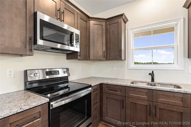 a kitchen with stainless steel appliances a sink a stove and microwave