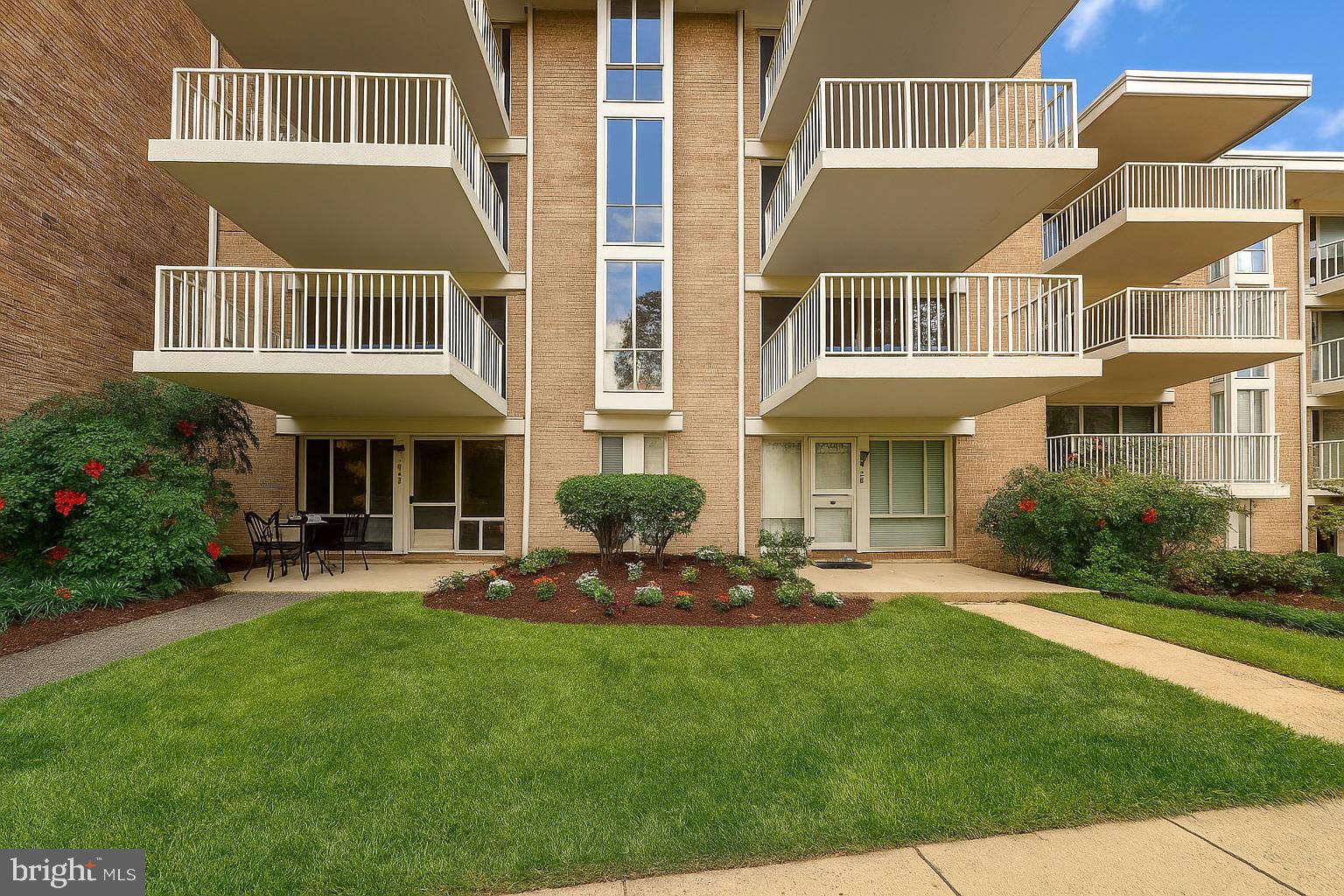 2605 Redcoat Drive, Unit 252 Alexandria, VA 22303 - Photo 1 of 26 a front view of a building with a yard table and chairs